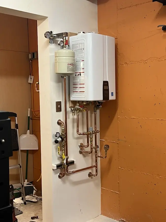 Plumbing technician inspecting water heater connections in Coto de Caza